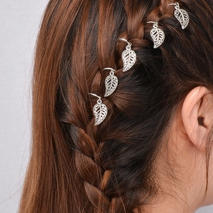 Five silver leaf hair rings shown on brown braided hair against a gray background