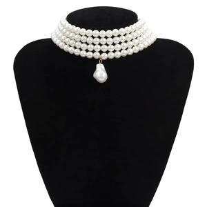 Elegante vierlaagse parelchoker ketting met een barokke parelhanger op een zwarte standaard