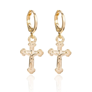 Détail de boucles d'oreilles crucifix dorées avec inscription INRI et relief