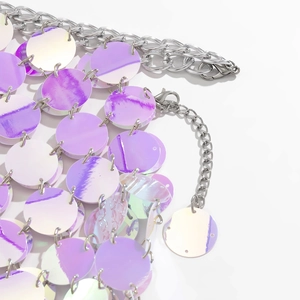 Close-up of iridescent purple sequins and silver metal chain body jewelry with lobster clasp