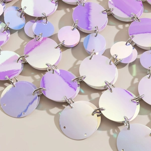 Macro view of colorful iridescent sequins and metal rings on a body chain accessory