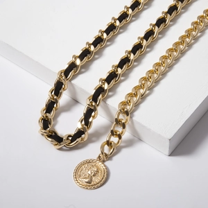 Detail of gold layered waist chain with black velvet ribbon and vintage coin pendant