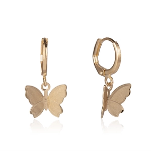 Close-up of golden butterfly pendant earrings featuring textured wings and round hoops