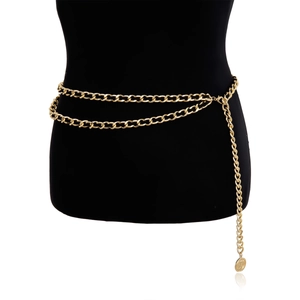 Detail of layered gold body chain featuring coin pendant on minimalist waist link