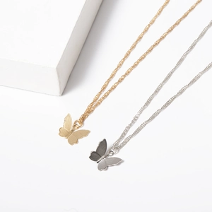Detail of minimalist gold and silver butterfly pendant necklaces with thin chain link