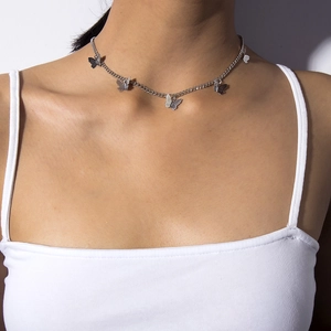 Close-up of minimalist silver necklace featuring five delicate butterfly pendants on model