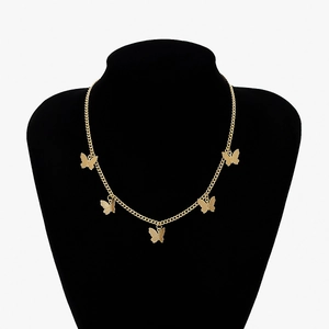 Detailed close-up of a gold butterfly fringe necklace on a black velvet neck mannequin