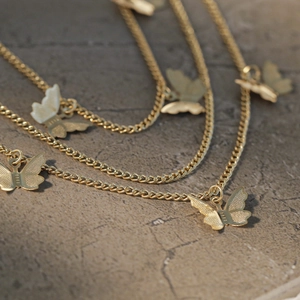 Punk style multi-layered gold body chain featuring delicate butterfly pendants and tassels