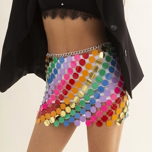 Dettaglio macro di paillettes arcobaleno e catene in metallo argento su gonna sexy