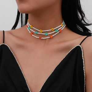 Gargantilla bohemia de tres capas con cuentas blancas y detalles de margaritas de colores