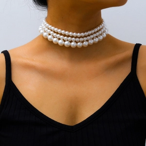 Collar gargantilla bohemio de tres capas con perlas blancas graduadas mostrado en una modelo