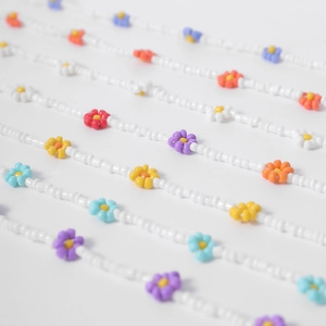 Primer plano macro de collares de cuentas de margaritas de colores y mostacilla blanca