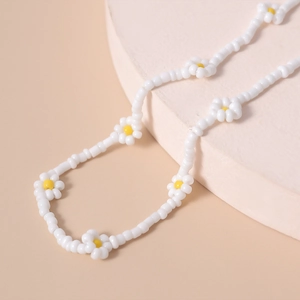 Primer plano del collar de cuentas hecho a mano con margaritas blancas y amarillas