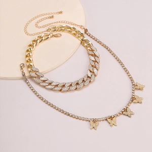 Detalle del collar de cadena dorada con diamantes de imitación y cinco mariposas