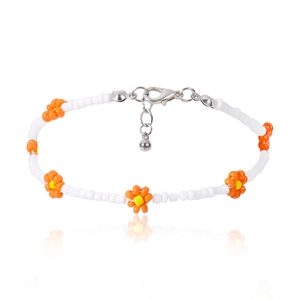 Detalle de collar artesanal de margaritas con flores naranjas y pequeñas cuentas blancas