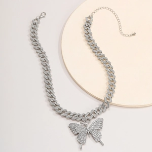 Nahaufnahme der silbernen Kubanischen Kette mit großem Schmetterling Anhänger und Strass