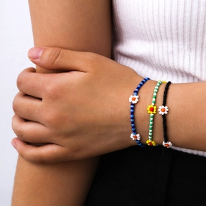 Primer plano de tres pulseras de cuentas de colores hechas a mano con motivos de margaritas