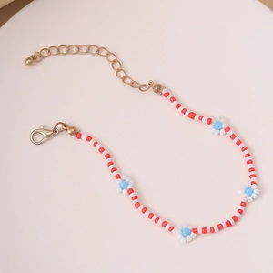 Detalle de collar de cuentas hecho a mano con flores blancas y cierre de langosta