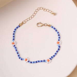 Detalle de collar de margaritas hecho a mano con cuentas azul-violeta y cierre dorado
