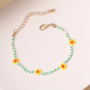 Detalle de pulsera de cuentas tejidas con flores de colores y cierre de langosta dorado