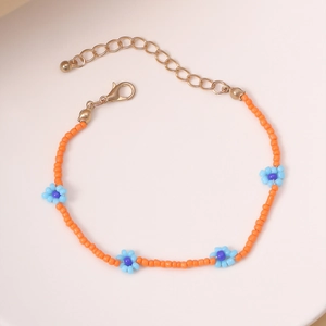 Detalle de la pulsera artesanal de cuentas naranjas con flores azules y cierre dorado