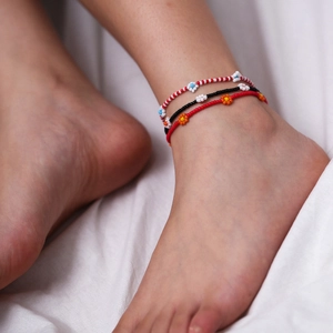 Tobilleras bohemias con cuentas de colores y patrones florales tejidos en el pie del modelo