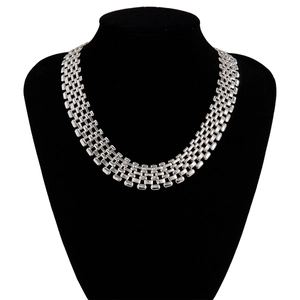 Macro detail of the wide silver woven chain links on a black velvet necklace display