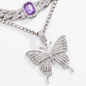 Detail einer kubanischen Panzerkette mit lila Edelstein und funkelndem Diamant-Schmetterling