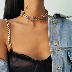 Detail of gold Cuban chain choker featuring three crystal butterflies in pink and purple