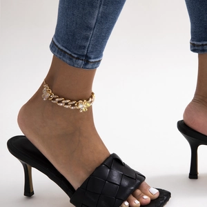 Detail of gold butterfly Cuban link anklet with rhinestones worn on ankle