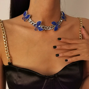 Detailed view of a silver Cuban link choker with five dark blue rhinestone butterflies
