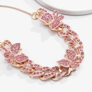 Macro detail of rose gold Cuban anklet featuring three pink rhinestone butterfly charms