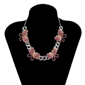 Close-up of a silver Cuban chain necklace featuring four pink butterfly crystal pendants