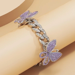 Close-up of Cuban link anklet with shimmering purple rhinestone butterflies on props