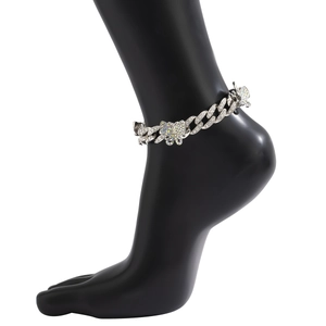 Detail of silver Cuban link anklet with shimmering crystals and colorful butterfly pendant