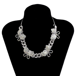 Detail of silver Cuban link necklace with colorful rhinestones on butterfly pendants