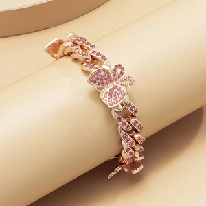 Detail of rose gold Cuban link anklet with pink rhinestones and a butterfly motif