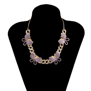 Detail of gold Cuban link necklace featuring four purple crystal encrusted butterflies