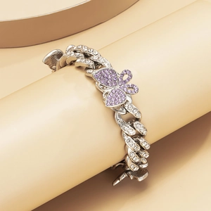 Detailed shot of silver butterfly anklet with purple rhinestones on Cuban link chain