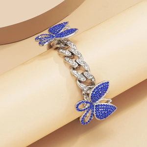 Close-up of silver Cuban link anklet featuring blue crystal butterfly charms