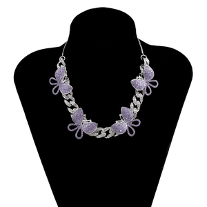 Detailed view of silver Cuban chain necklace with four purple rhinestone butterflies