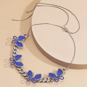 Detailed macro view of Cuban link necklace featuring blue rhinestone butterfly pendants