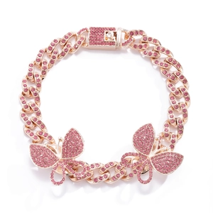 Macro detail of pink rhinestone encrusted Cuban chain anklet with butterfly pendants