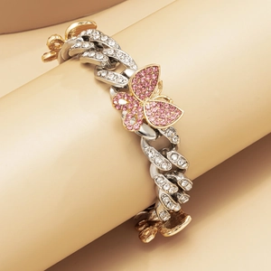 Detailed macro view of an iced-out Cuban chain butterfly anklet with pink rhinestones