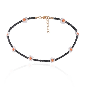 Macro-detail van de Boho kralenketting met madeliefjespatronen en gouden sluiting