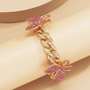 Close-up of golden Cuban chain anklet with pink rhinestone butterfly pendants