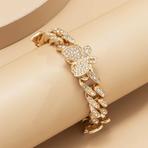 Close-up of gold Cuban link anklet with crystal-encrusted butterfly charm detail