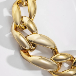 Macro view of chunky golden chain link necklace with a high-gloss polished metallic finish