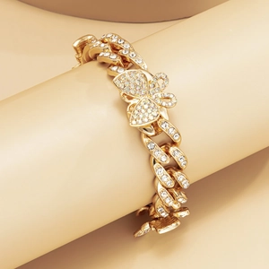 Close-up of a gold-plated butterfly Cuban chain anklet with sparkling crystal pavé detail