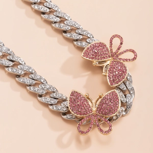 Detailed macro view of punk silver Cuban chain with diamond encrusted pink butterfly charms